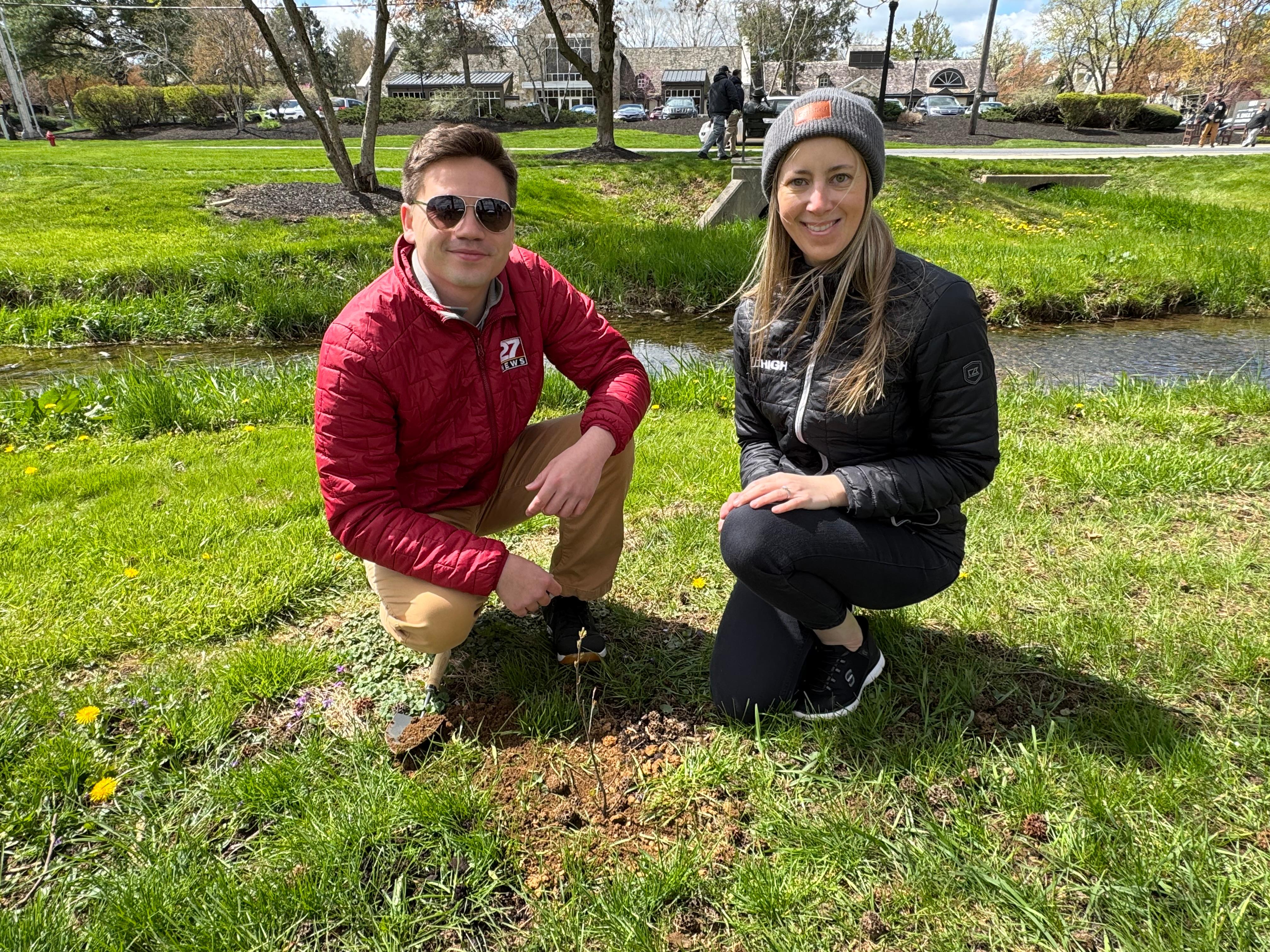 Man and Woman smiling in front of newly planted tree in Greenfield 